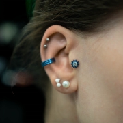 Kryształ otoczony kulkami tworząc kwiat - tytanowy labret. Kolczyk do piercingu ucha - helix, lobe, flat, tragus, conch. Kolor niebieski, anodyzacja.