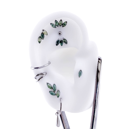 Agat mszysty - gałązka łezka listek - tytanowy labret ozdobny. Imitacja naturalnego kamienia Moss Agate. Kompozycja na sztucznym uchu, dużo kolczyków. Piercing ucha helix flat lobe tragus conch upper lobe.