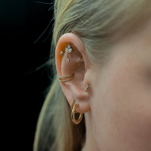 Kryształowy kwiat lotosu z wiszącą cyrkonią - tytanowy ozdobny labret. Kolczyk do piercingu ucha - flat, lobe. Kompozycja stylizacja ucha złoto.